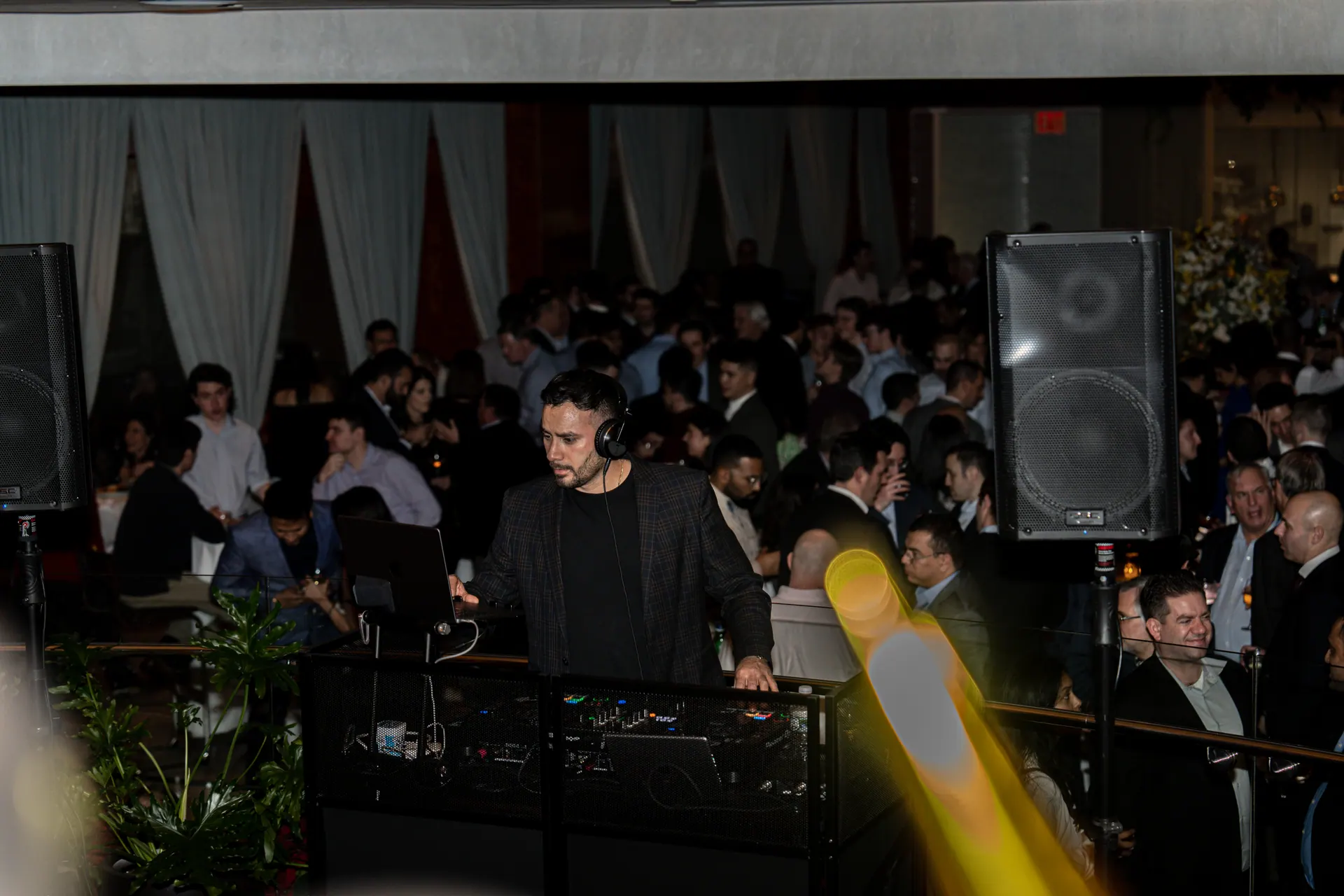 A full corporate crowd seen from behind the DJ booth